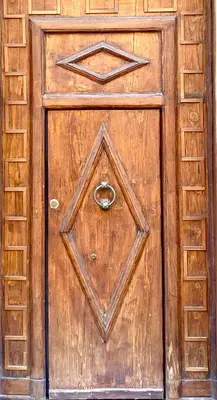 an old wooden door with a ring on it at Casa 900 in Castellammare del Golfo