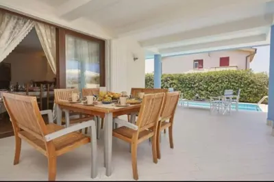 a dining room with a wooden table and chairs at Villa Costantino in Trappeto