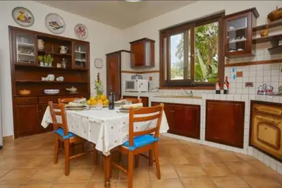 a kitchen with a white table and chairs in a kitchen at Villa Costantino in Trappeto