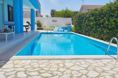 a swimming pool with blue water in a yard at Villa Costantino in Trappeto