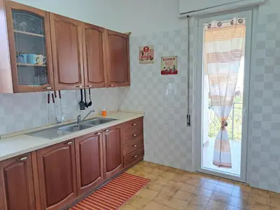 a kitchen with a sink and a sliding glass door at Anastasia's House in Trabia