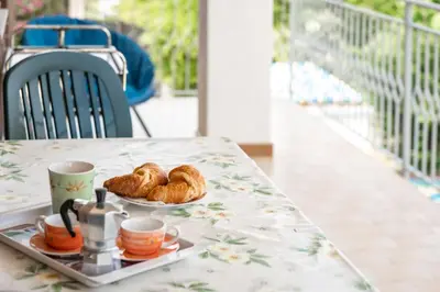 a tray of croissants and cups on a table at Anastasia's House in Trabia