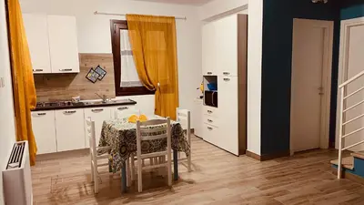a kitchen with a table and a kitchen with a sink at L'angolo in centro in Partinico