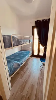 a bedroom with two bunk beds and a wooden floor at L'angolo in centro in Partinico