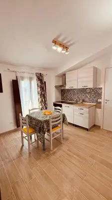 a kitchen with a table and chairs in a room at L'angolo in centro in Partinico