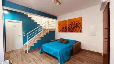 a bedroom with a bed and a staircase at L'angolo in centro in Partinico