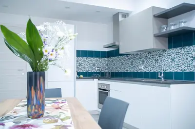 a kitchen with a table with a vase of flowers at La Chiostrina in Castellammare del Golfo