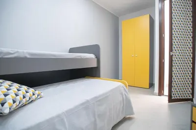 a bedroom with a bunk bed and a yellow door at La Chiostrina in Castellammare del Golfo