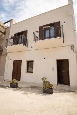 a white building with two balconies and two doors at La Chiostrina in Castellammare del Golfo