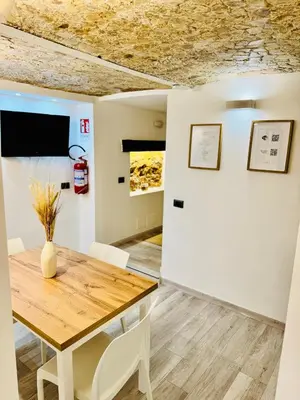 a dining room with a wooden table and chairs at Centro Storico Palermo Stationsuite N5 WiFi Tutto a Piedi! in Palermo