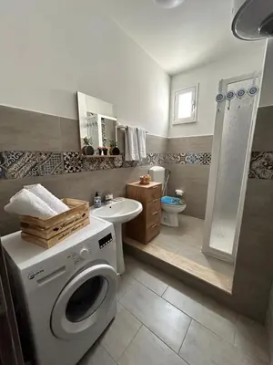 a bathroom with a washing machine and a sink at PortAzzurra in Carini