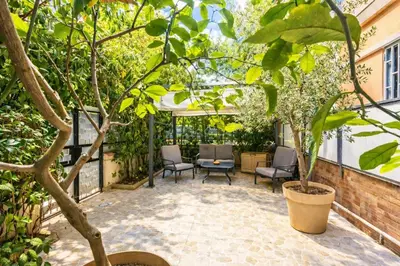 a patio with chairs and trees in a building at Giardino Lussemburgo, Elegante e confortevole appartamento tra Mondello e il centro storico di Palermo in Palermo