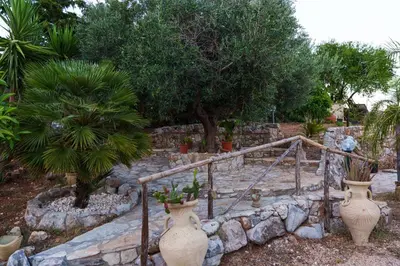 two large vases sitting next to a stone staircase at Al ficodindia in Scopello