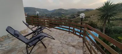 a pair of chairs sitting on a balcony with a bridge at Al ficodindia in Scopello