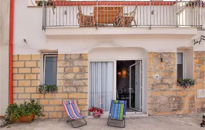 two chairs sitting outside of a building with a balcony at Amazing Home In Trappeto With Wifi in Trappeto