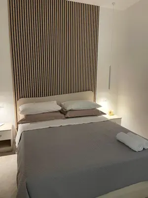 a bedroom with a large bed with a wooden headboard at Casa vacanze Soraja in Palermo