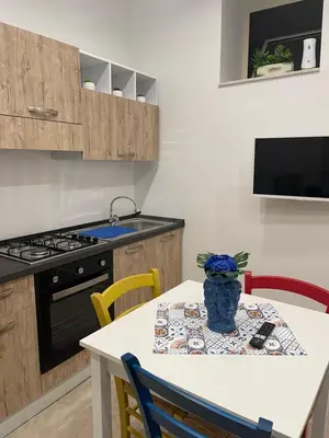 a kitchen with a table with chairs and a stove at Casa vacanze Soraja in Palermo