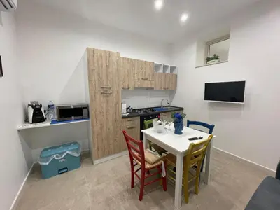 a small kitchen with a table and chairs in a room at Casa vacanze Soraja in Palermo