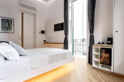 a white bedroom with a bed and a fireplace at Hibrido in Palermo
