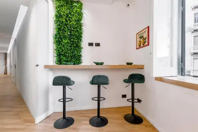 two stools in a hallway with a green wall at Hibrido in Palermo