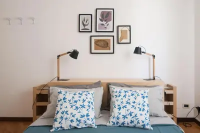 a bedroom with two lamps and a bed with pillows at Casa Sul Mare Seaside apt in front of the sea in Palermo