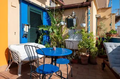 a small patio with a blue table and chairs at Bella Vista Sant Orsula 2 bedroom View Terrace Historic Center Spacious Apartment in Termini Imerese