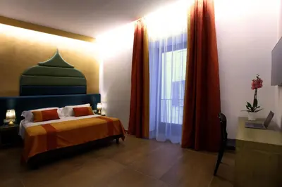 a bedroom with a bed and a large window at Palazzo Cartari in Palermo