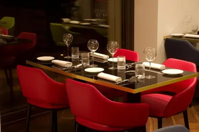 a dining room table with red chairs and wine glasses at Palazzo Cartari in Palermo