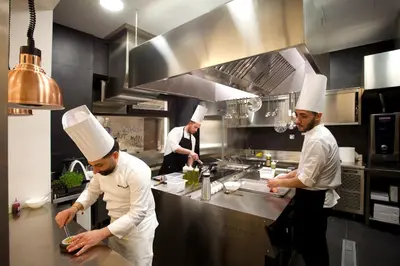 a group of chefs preparing food in a kitchen at Palazzo Cartari in Palermo