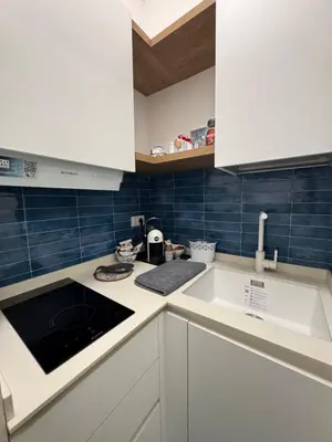 a kitchen with white cabinets and a sink at Casa Vacanze Marinella Beach in San Vito lo Capo