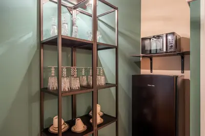 a shelf with glasses and a refrigerator in a room at Aurora Apartment by Domus Sicily in Palermo
