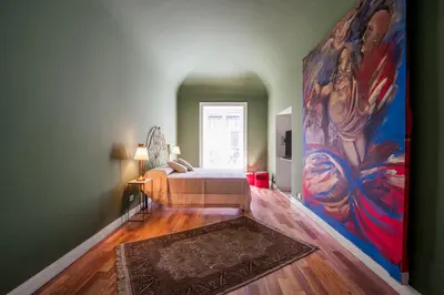 a bedroom with a bed and a large painting on the wall at Aurora Apartment by Domus Sicily in Palermo