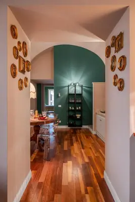 a dining room with a table and a green wall at Aurora Apartment by Domus Sicily in Palermo