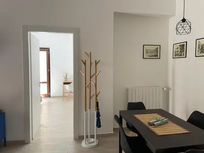 a dining room with a table and a room with aearcher at Casa Giura in Palermo