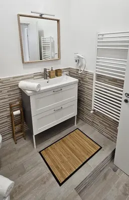 a bathroom with a white sink and a mirror at Casa Giura in Palermo