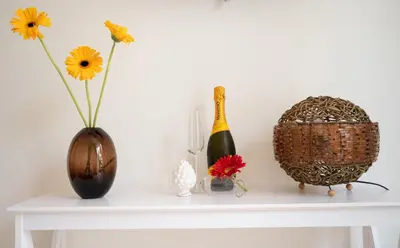 a white table with two vases and a basket with flowers at Posidonia B&B in Terrasini