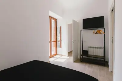 a bedroom with a bed and a flat screen tv at Ballaro' House in Palermo