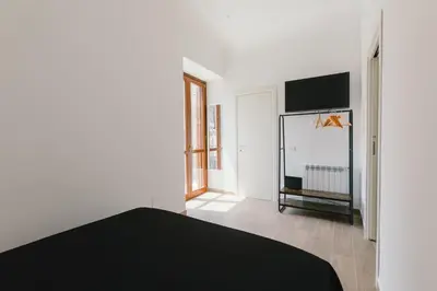 a bedroom with a black bed and a flat screen tv at Ballaro' House in Palermo