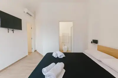 a white room with two towels on a bed at Ballaro' House in Palermo