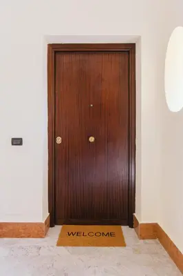 a wooden door with a welcome mat in front of it at Ballaro' House in Palermo