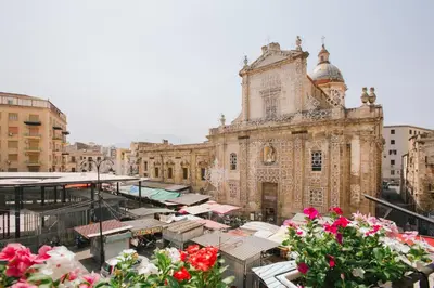 an old building with flowers in front of it at Ballaro' House in Palermo
