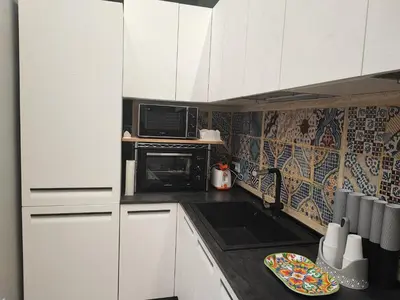 a small kitchen with white cabinets and a microwave at Casa da Giannina in Palermo