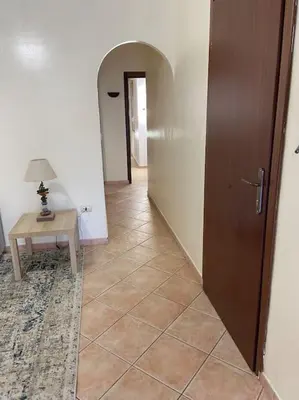 a hallway with a table and a door and a table and a lamp at Casa Peppino in Palermo