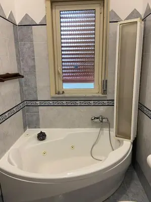 a white bath tub in a bathroom with a window at Casa Peppino in Palermo