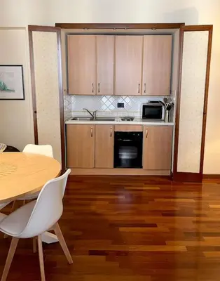 a kitchen with wooden floors and a table and a microwave at La casa del Maestro in Palermo