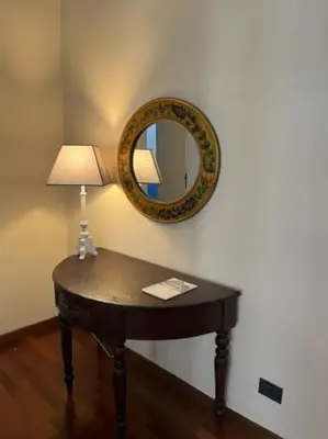 a table with a lamp and a mirror on a wall at La casa del Maestro in Palermo