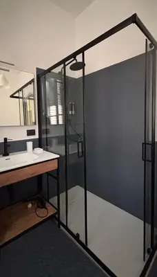 a bathroom with a shower with a sink and a mirror at La casa del Maestro in Palermo
