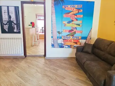 a living room with a couch and a wall with posters at Villemar in Isola delle Femmine