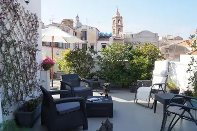a patio with chairs and tables on a balcony at Guascone Apartments in Palermo