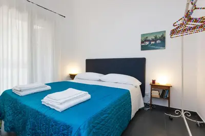 a bedroom with a blue bed with towels on it at Guascone Apartments in Palermo